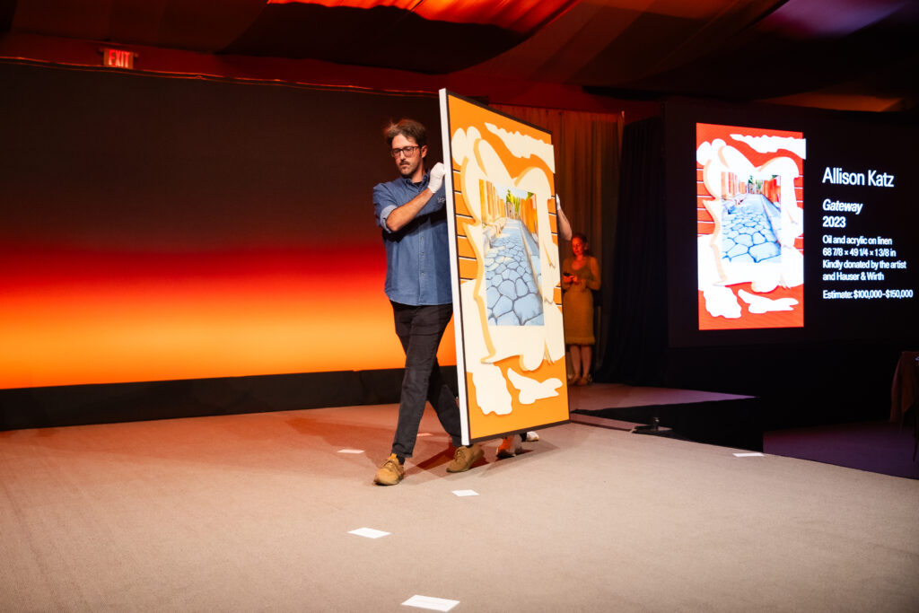 UOVO art handler carrying Allison Katz 'Getaway’ painting at Aspen Art Museum’s 2024 ArtCrush Gala.